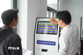 Hướng dẫn người dân lấy số thứ tự khi thực hiện thủ tục hành chính tại Trung tâm Phục vụ hành chính công xã Hỏa Lựu (Cần Thơ). (Ảnh: Hồng Thái/TTXVN)
