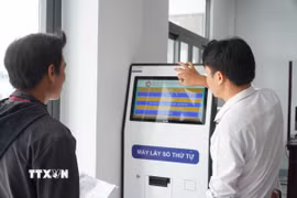 Hướng dẫn người dân lấy số thứ tự khi thực hiện thủ tục hành chính tại Trung tâm Phục vụ hành chính công xã Hỏa Lựu (Cần Thơ). (Ảnh: Hồng Thái/TTXVN)
