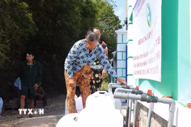 Người dân xã Vĩnh Châu nhận nước sạch miễn phí. (Ảnh: Thu Hiền/TTXVN)