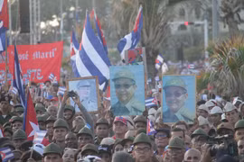 Người dân giơ cao hình ảnh nhà lãnh đạo cách mạng Raúl Castro trong cuộc mít tinh ở thủ đô La Habana. (Ảnh: Ngọc Duy/TTXVN)