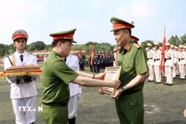 Trung tướng Nguyễn Ngọc Vân, Tư lệnh Cảnh sát cơ động, phó Trưởng Tiểu ban Thường trực tổ chức diễu binh, diễu hành (Bộ Công an) tặng Bằng khen của Bộ Công an cho các học viên có thành tích xuất sắc tham gia diễu binh, diễu hành trong Lễ kỷ niệm. (Ảnh: Lê Xuân/TTXVN)