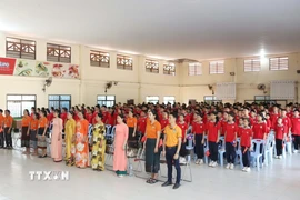 Thầy trò Trường song ngữ Lào-Việt Nam Nguyễn Du thực hiện nghi thức Chào cờ trước giờ xem truyền hình trực tiếp Lễ kỷ niệm 50 năm Giải phóng miền Nam, thống nhất đất nước.(Ảnh: Xuân Tú/TTXVN)