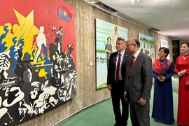 Bí thư toàn quốc PCF Fabien Roussel giới thiệu với Đại sứ Việt Nam tại Pháp Đinh Toàn Thắng một bức tranh cổ động được các họa sĩ Pháp thể hiện vào những năm 1960. (Ảnh: Nguyễn Thu Hà/TTXVN)