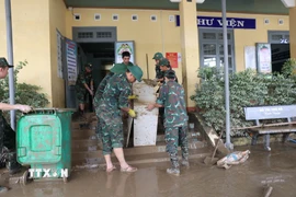 Sau lũ, bùn đất “bủa vây” các trường học, lực lượng quân đội tổ chức dọn vệ sinh để học sinh sớm quay lại trường. (Ảnh: Tuấn Anh/TTXVN)