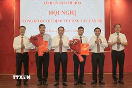 Thường trực Tỉnh ủy Khánh Hòa trao quyết định và tặng hoa chúc mừng ông Tạ Hồng Quang (bên trái) và nhà báo Lê Hoàng Triều (bên phải). (Ảnh: Xuân Triệu/TTXVN)