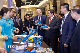 Chủ tịch Quốc hội Trần Thanh Mẫn và đại biểu tham quan gian hàng của Vietnam Airlines. (Ảnh: Doãn Tấn/TTXVN)
