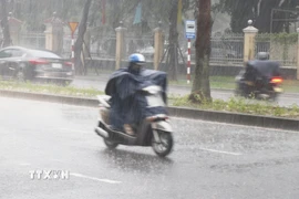 Người dân đi lại trong mưa lớn sáng 27/9/2025 trên đường Đống Đa, phường Thuận Hóa, thành phố Huế. (Ảnh: Nguyên Lý/TTXVN)