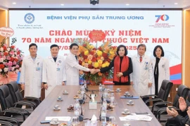 Phó Chủ tịch Quốc hội Nguyễn Thị Thanh tặng hoa chúc mừng tập thể y bác sĩ Bệnh viện Phụ sản Trung ương. (Ảnh: Minh Quyết/TTXVN)