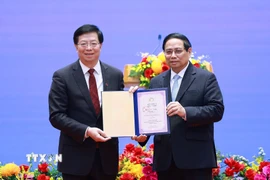 Ông Khưu Dũng, Bí thư Đảng ủy Đại học Thanh Hoa, Trung Quốc trao tặng Thủ tướng Phạm Minh Chính danh hiệu "Giáo sư danh dự Đại học Thanh Hoa." (Ảnh: Dương Giang/TTXVN)