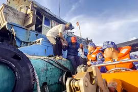 Lực lượng cảnh sát biển tiếp cận tàu cá, đón ngư dân lên tàu cấp cứu. (Ảnh minh họa: TTXVN phát)