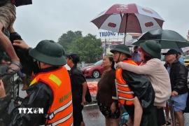 Lực lượng vũ trang Huế hỗ trợ di dời dân, tài sản khỏi khu vực nguy hiểm. (Ảnh: TTXVN phát)