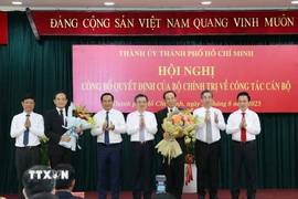 Các đồng chí Thường trực Thành ủy Thành phố Hồ Chí Minh tặng hoa chúc mừng đồng chí Nguyễn Văn Nên và đồng chí Trần Lưu Quang. (Ảnh: Tiến Lực/TTXVN)