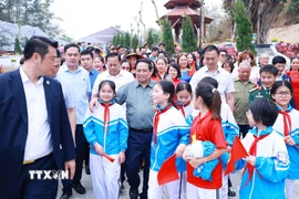 Thủ tướng Phạm Minh Chính với học sinh tỉnh Điện Biên dự Lễ khánh thành công trình bảo tồn, tôn tạo di tích Khu trung tâm đề kháng Him Lam (giai đoạn II). (Ảnh: Dương Giang/TTXVN)