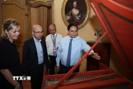 Thủ tướng Phạm Minh Chính và Phu nhân xem hiện vật về nghệ thuật chế tác dụng cụ âm nhạc trưng bày tại Bảo tàng lịch sử và nghệ thuật Palais Lascaris. (Ảnh: Dương Giang/TTXVN)