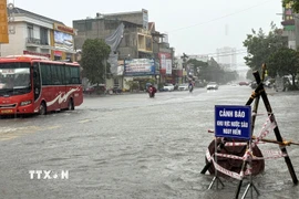 Tuyến đường huyết mạch Nguyễn Trãi, phường Hạc Thành, tỉnh Thanh Hóa ngập, phải dựng biển cảnh báo cho phương tiện tham gia giao thông. (Ảnh: Việt Hoàng/TTXVN)