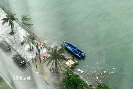 Chuyển thi thể vừa tìm được trong vụ lật tàu tại Hạ Long lên bờ để xác minh danh tính. (Ảnh: TTXVN phát)