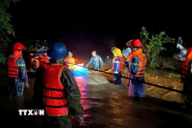 Lực lượng chức năng xã Yang Mao di dời các hộ dân vùng ngập lụt đên nơi an toàn trong đêm. (Ảnh: TTXVN phát)