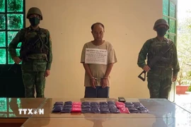 Đối tượng Xải Khư Lỳ (tên khác: Lỳ Xải Khư) cùng tang vật tại cơ quan chức năng. (Ảnh: TTXVN phát)