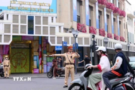 Lực lượng Cảnh sát giao thông điều tiết, phân luồng giao thông tại nút giao phố Tràng Tiền - Đinh Tiên Hoàng, Hà Nội trong sáng mùng 1 Tết. (Ảnh: Phạm Kiên/TTXVN)