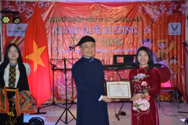 Đại sứ Ngô Hướng Nam trao bằng khen cho đại diện công ty VinFast Hà Lan vì những đóng góp tích cực trong công tác hỗ trợ cộng đồng. (Ảnh: TTXVN phát)