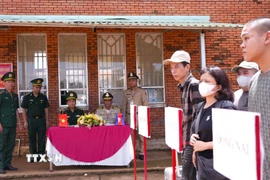 Lực lượng chức năng Việt Nam-Campuchia làm thủ tục bàn giao, tiếp nhận 15 công dân Việt Nam tại Cửa khẩu quốc tế Xa Mát, xã Tân Lập, tỉnh Tây Ninh. (Ảnh: Minh Phú/TTXVN) 