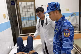 Y bác sĩ Trung tâm Y tế Quân, Dân y huyện Côn Đảo thăm, khám cho thủy thủ bị bệnh. (Ảnh: TTXVN phát)