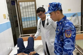 Y bác sĩ Trung tâm Y tế Quân, Dân y huyện Côn Đảo thăm, khám cho thủy thủ bị bệnh. (Ảnh: TTXVN phát)