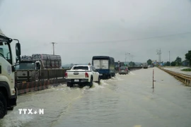 Tuyến Quốc lộ 1A đoạn qua 2 xã Hà Trung và Hoạt Giang (tỉnh Thanh Hóa) bị ngập nặng, các phương tiện lưu thông khó khăn. (Ành: Hoa Mai/TTXVN) 