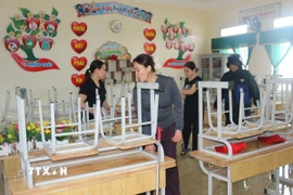 Giáo viên Trường Tiểu học Đỉnh Bàn, xã Thạch Khê, dọn dẹp trường lớp sau bão. (Ảnh: Hoàng Ngà/TTXVN)
