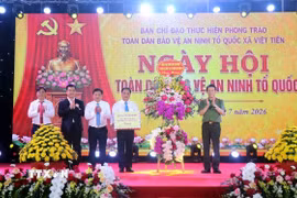 Đại tướng Lương Tam Quang, Ủy viên Bộ Chính trị, Bộ trưởng Bộ Công an tặng hoa chúc mừng xã Việt Tiến, tỉnh Hưng Yên. (Ảnh: Đinh Văn Nhiều/TTXVN)