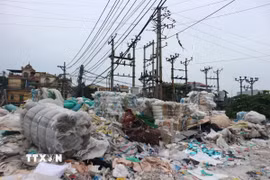 Trạm biến áp điện ở làng nghề Minh Khai bị rác thải nhựa quây kín, tiềm ẩn nguy cơ cháy nổ. (Ảnh: Mạnh Khánh/TTXVN)