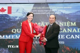 Ông Hồ Xuân Lâm, Phó Chủ tịch kiêm Tổng thư ký Liên hiệp các tổ chức hữu nghị Thành phố Hồ Chí Minh, tặng hoa chúc mừng bà Annie Dube, Tổng Lãnh sự Canada tại Thành phố Hồ Chí Minh. (Ảnh: Xuân Khu/TTXVN)