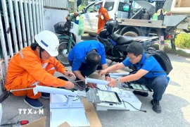 Các kỹ sư trẻ thử nghiệm mô hình lưới điện. (Ảnh: TTXVN phát)