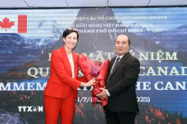 Ông Hồ Xuân Lâm, Phó Chủ tịch kiêm Tổng thư ký Liên hiệp các tổ chức hữu nghị Thành phố Hồ Chí Minh, tặng hoa chúc mừng bà Annie Dube, Tổng Lãnh sự Canada tại Thành phố Hồ Chí Minh. (Ảnh: Xuân Khu/TTXVN)