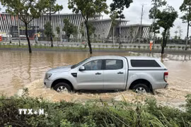 Nước ngập sâu khiến các phương tiện lưu thông khó khăn. (Ảnh: Quốc Lũy/TTXVN)