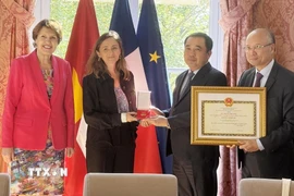 Quyền Bộ trưởng Bộ Nông nghiệp và Môi trường Trần Đức Thắng trao tặng Kỷ niệm chương vì sự nghiệp nông nghiệp và phát triển nông thôn cho bà Marion Chaminade, nguyên Tham tán Nông nghiệp tại Đại sứ quán Pháp tại Việt Nam. (Ảnh: Hữu Chiến/TTXVN) 