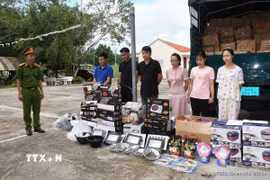 Các đối tượng bị bắt cùng tang vật. (Ảnh: TTXVN phát)