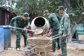 Các chiến sỹ Trung đoàn 974 khẩn trương làm việc tại công trình nhà ở sau lũ hộ ông Hà Quyn, thôn Đá Trắng, xã Nam Khánh Vĩnh. (Ảnh: Phan Sáu/TTXVN)
