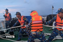 Các chiến sĩ giúp một tàu ngư dân bị nạn. (Ảnh: TTXVN phát)