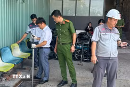 Cơ quan chức năng thu mẫu nước thải của bệnh viện S.I.S để kiểm tra. (Ảnh: TTXVN phát)