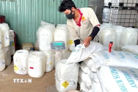 Công nhân trộn và đóng gói sản phẩm từ các nguyên liệu có nguồn gốc xuất xứ nước ngoài rồi dán tem, nhãn. (Ảnh: TTXVN phát)