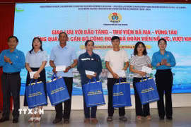 Bà Nguyễn Kim Loan, Phó Chủ tịch Liên đoàn Lao động Thành phố Hồ Chí Minh tặng quà cho công nhân lao động có hoàn cảnh khó khăn tại tọa đàm, giao lưu. (Ảnh: Thanh Vũ/TTXVN)