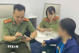 Cán bộ Phòng An ninh mạng và phòng chống tội phạm sử dụng công nghệ cao giải thích cho bà B về thủ đoạn của các đối tượng lừa đảo. (Ảnh: TTXVN phát)