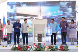 Phó Thủ tướng hai nước Lào-Thái Lan và đại diện các bộ, ngành hai nước thực hiện nghi thức đổ bê tông hợp long cầu. (Ảnh: Xuân Tú/TTXVN)