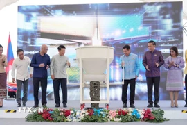 Phó Thủ tướng hai nước Lào-Thái Lan và đại diện các bộ, ngành hai nước thực hiện nghi thức đổ bê tông hợp long cầu. (Ảnh: Xuân Tú/TTXVN)