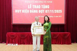 Phó Bí thư Thường trực Tỉnh ủy Bắc Ninh Nguyễn Thị Hương trao tặng Huy hiệu 75 năm tuổi đảng cho đồng chí Nguyễn Nhâm, phường Vũ Ninh. (Ảnh: Thanh Thương/TTXVN) 