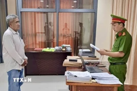 Cơ quan Cảnh sát điều tra tống đạt Quyết định khởi tố bị can đối với Trần Văn Ba. (Ảnh: TTXVN phát)