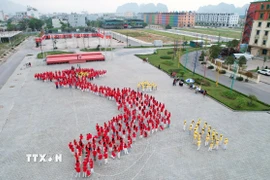 500 học sinh xếp hình lá cờ Tổ quốc. (Ảnh: Văn Đức/TTXVN)
