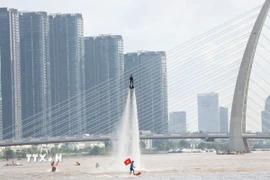 Tiết mục bay bằng ván phản lực nước - Flyboard trên sông Sài Gòn. (Ảnh: Thu Hương/ TTXVN)