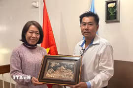 Đại sứ Ngô Minh Nguyệt tặng quà lưu niệm cho kiều bào tại Posadas. (Ảnh: Diệu Hương/TTXVN)